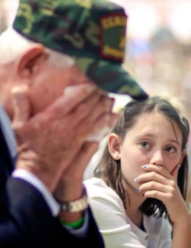 A granddaughter watching her grandfather cry at her school's Veteran's Day assembly