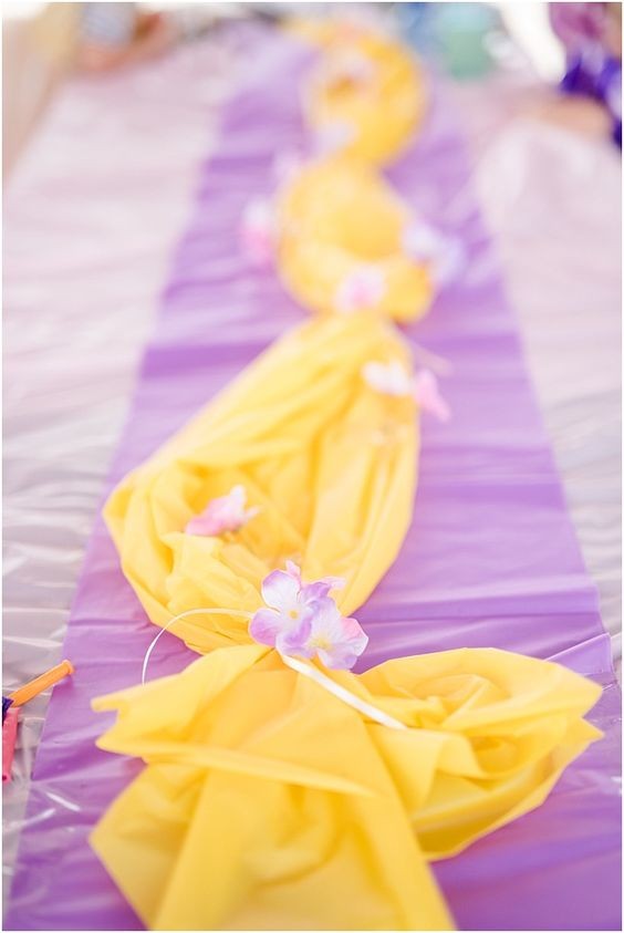 1. Carta velina viola per il runner su cui adagiare una "treccia" fatta di carta velina gialla e fiori: è un'idea che ricorda la magnifica capigliatura di Rapunzel