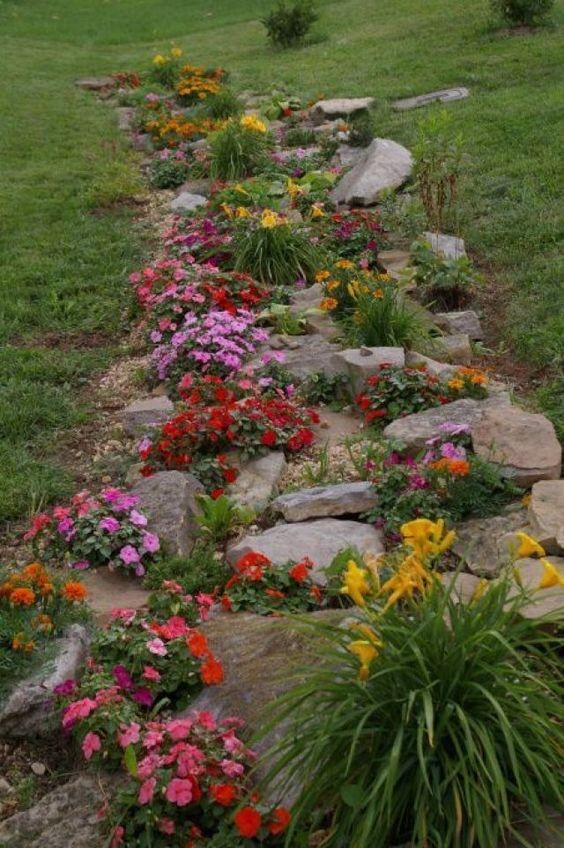5. À un endroit de la pelouse où il y a des irrégularités dans le sol, vous pourriez installer une sorte de parterre de fleurs comme celui-ci, avec des roches et des fleurs