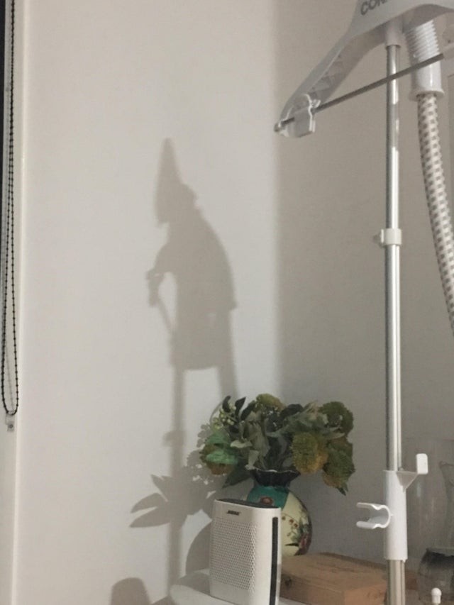 Der Schatten der Bügelmaschine sieht aus wie eine Hexe.