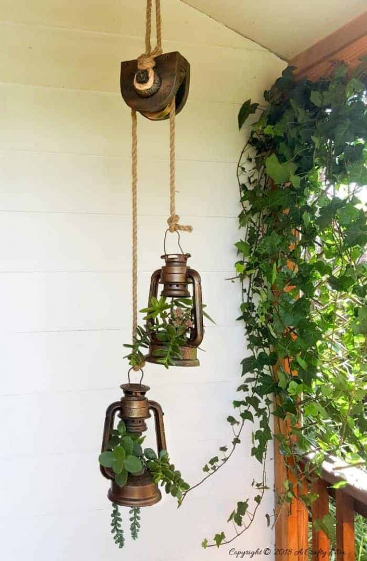 2. Una carrucola che regge due lampade a olio in cui sono state piantate delle varietà succulente. Potreste provare anche con le tillandsiae
