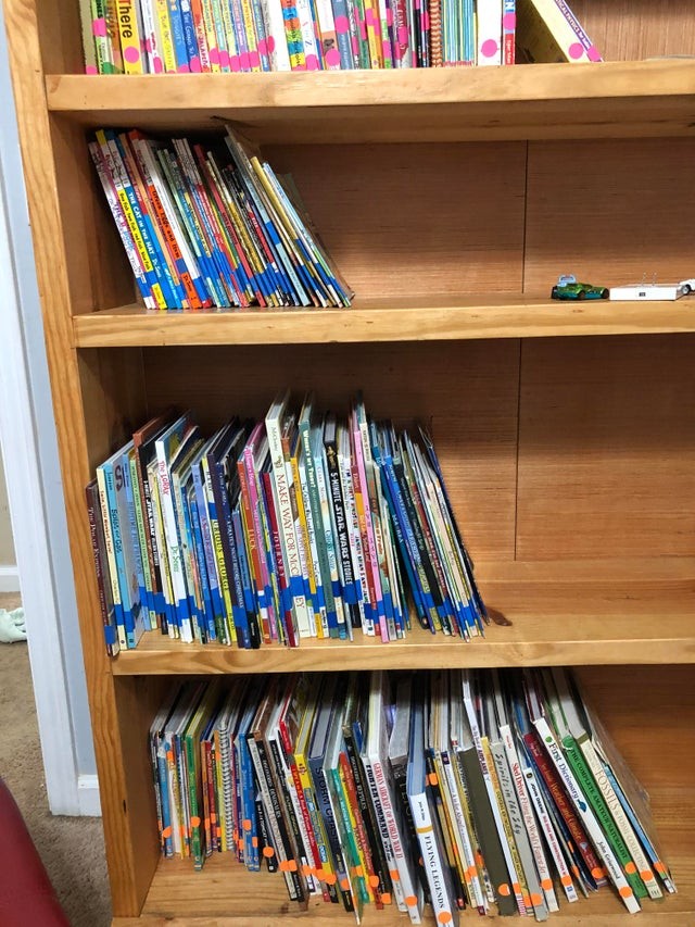 "Sorteer de boeken per type (bedtijdverhalen, kleurboeken, schoolboeken...) en plak gekleurde plakband op de achterkant zodat de kinderen eenvoudig het boek kunnen kiezen."