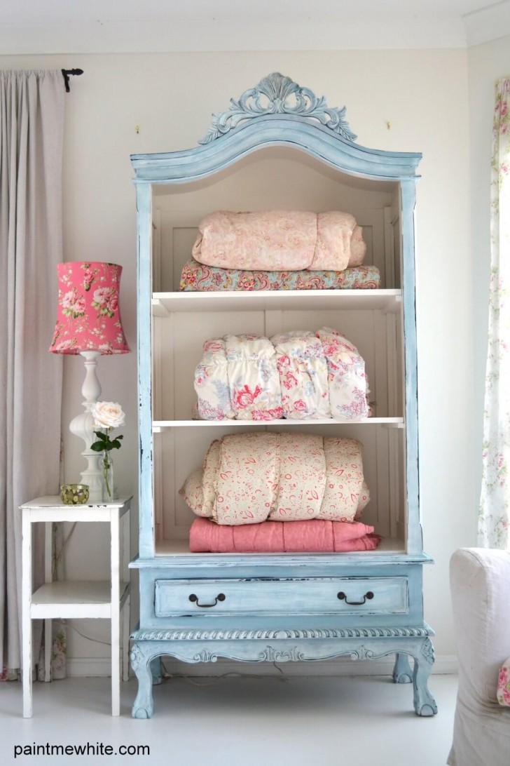 2. Celeste e rosa, e tanti motivi floreali: ecco un mobile dipinto con effetto trasandato per ospitare coperte, plaid e cuscini extra
