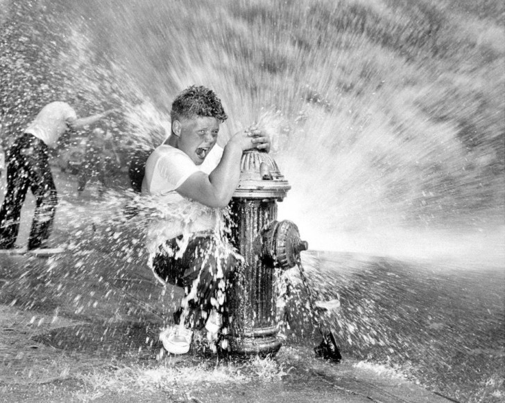 Ein Junge spielt mit einem kaputten Hydranten (New York, 1959)