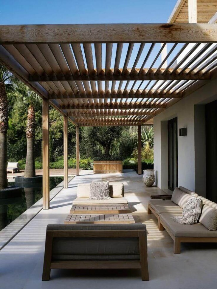 1. Una splendida pergola con lamelle di legno che corre attorno alla casa, creando un patio arioso e moderno