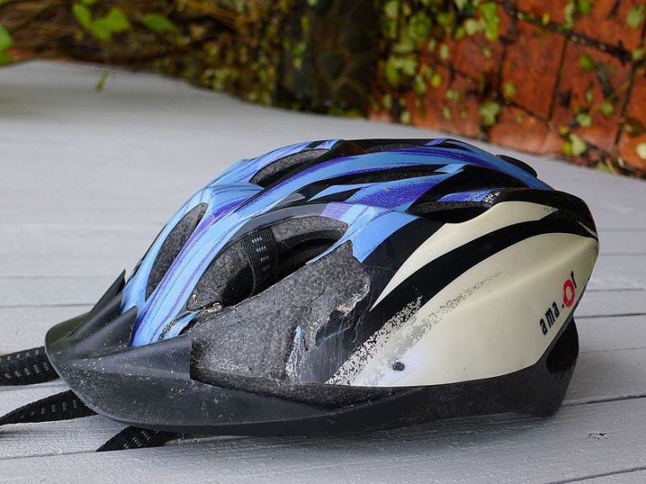 10. Offensichtlich gebrochener Helm eines Radfahrers nach Aufprall auf dem Boden