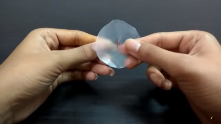 3. Ritagliate un dischetto di plastica dal diametro appena più piccolo di quello del bicchiere e praticate al centro un foro per far passare lo stoppino
