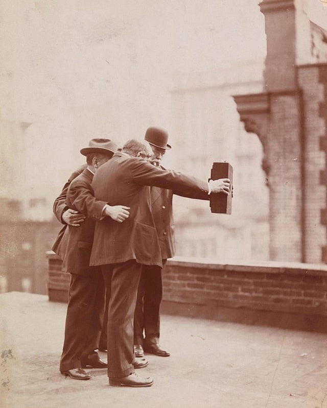 Quatre hommes essayant de se faire un selfie à l'ancienne : ce sont les années 20 !