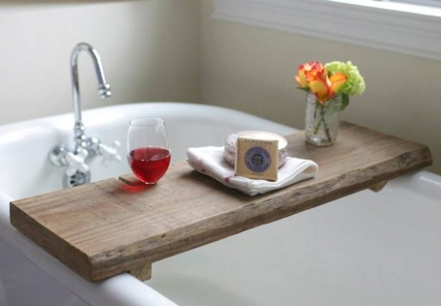 7. Una tavola di legno diventa un pratico vassoio portaoggetti per rilassarsi nella vasca da bagno