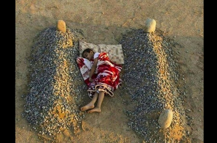 3. La didascalia di questa foto sosteneva si trattasse di un bimbo siriano che dormiva tra le tombe dei suoi genitori. In realtà è il nipote del fotografo e ai suoi lati ci sono dei semplici cumuli di pietre posizionate in modo che sembrino delle tombe