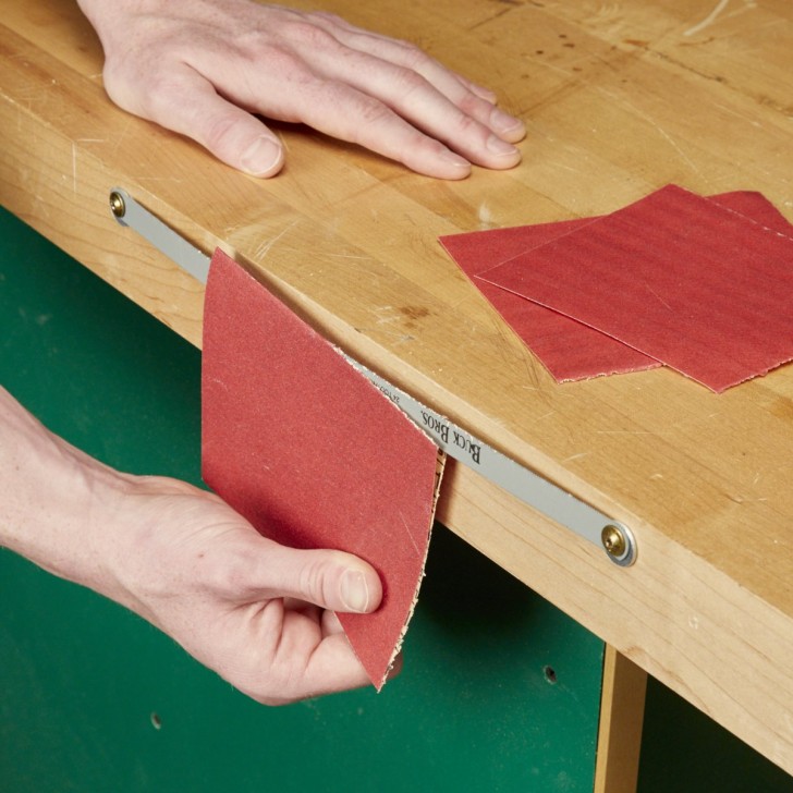 8. Una lama sistemata sul bordo laterale di un ripiano da lavoro, per tagliare comodamente strappi di carta vetro (e non solo)