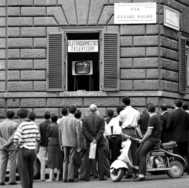 Les habitants d'un quartier romain regardent les Jeux olympiques à la télévision par la fenêtre : 1960