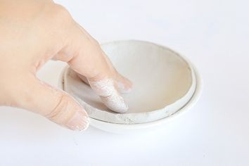 3. Usando il piattino come stampo, appiattite delicatamente l'argilla al suo interno, per ricalcarne la forma
