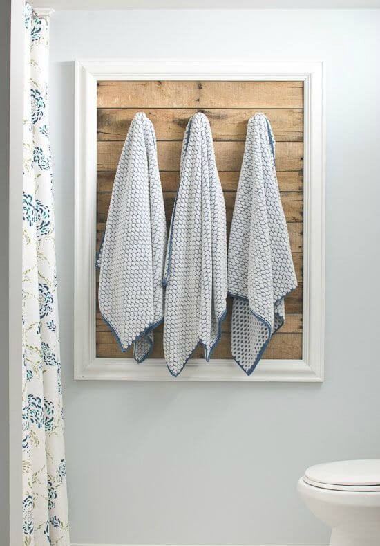 7. Questo pannello di legno di recupero incorniciato è molto meglio di semplici ganci a parete per appendere gli asciugamani