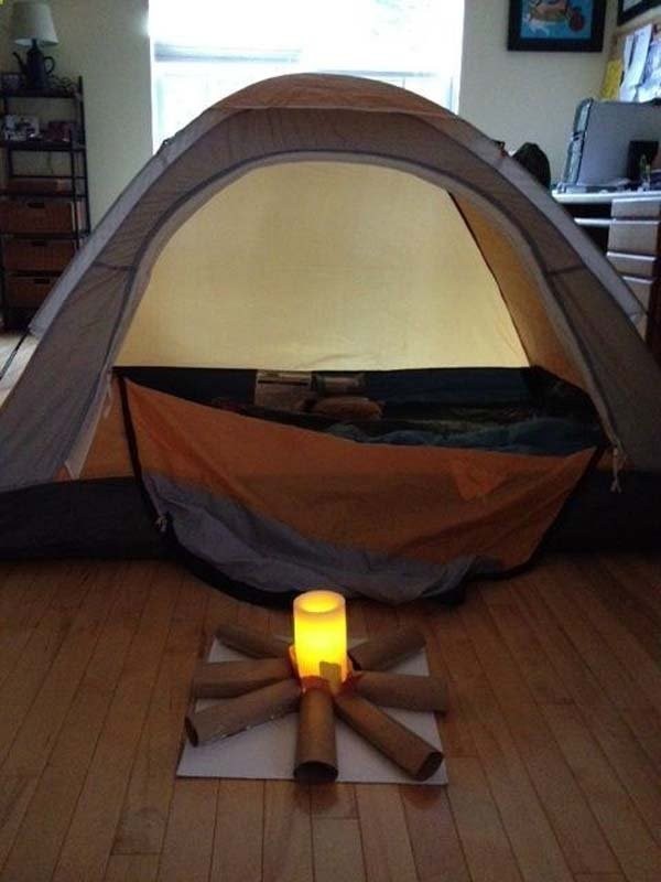 11. Tirate fuori la tenda da campeggio e create un fuoco finto con carta e candele elettriche per trasformare il salotto in uno spazio magico