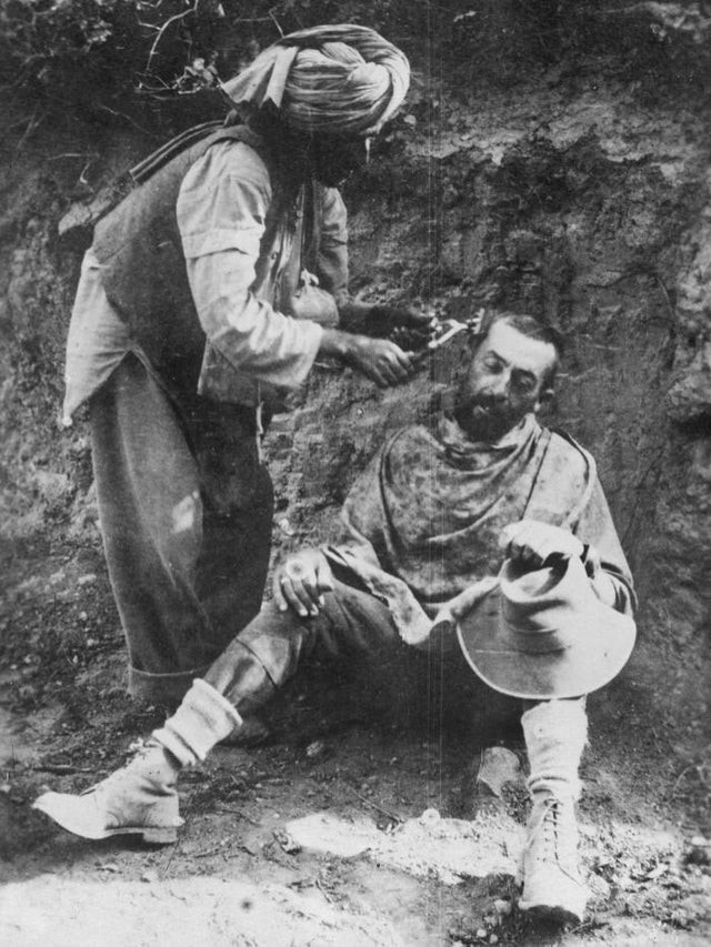 19. Un soldat indien coupe les cheveux d'un soldat australien dans les tranchées de Gallipoli, en Turquie (1915)