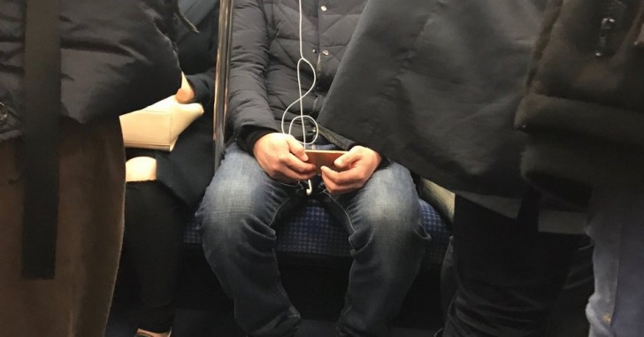 A guy listens to music on his cell phone, and his headphone cord seems to give life ... to a musical note!
