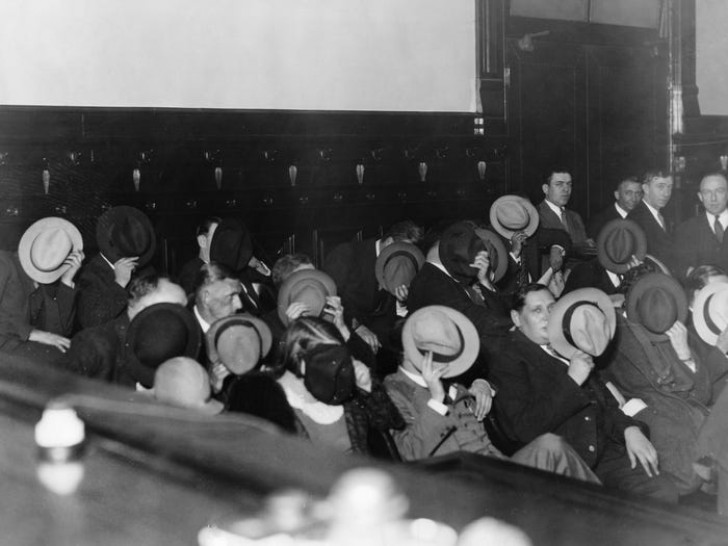 I gangster si coprono il volto con il capello durante il processo ad Al Capone, 1931. 