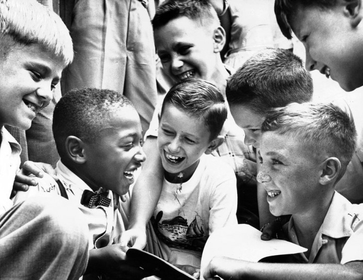 Un petit garçon noir retourne à l'école, accueilli par ses camarades de classe, 4 mois après que la Cour suprême a statué que la ségrégation raciale est inconstitutionnelle, en 1954