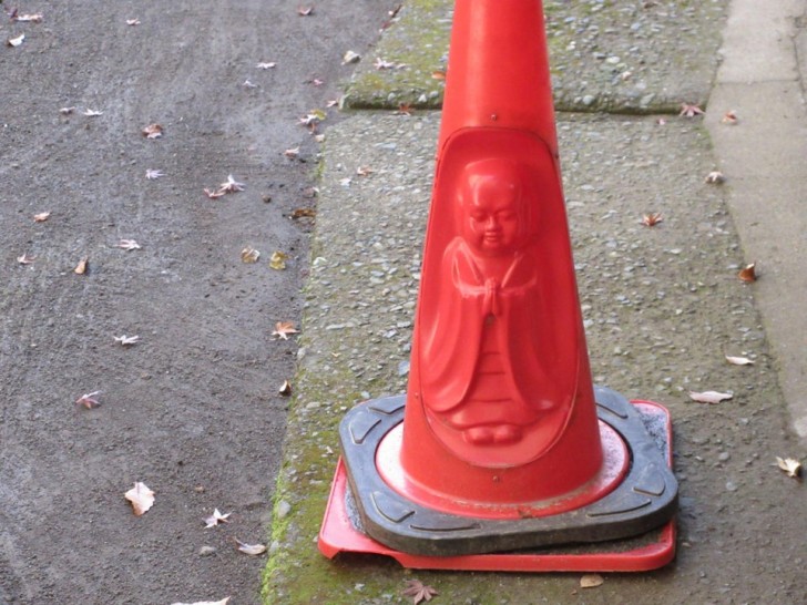 Un cono segnaletico con la forma di un Buddha in un tempio in Giappone.