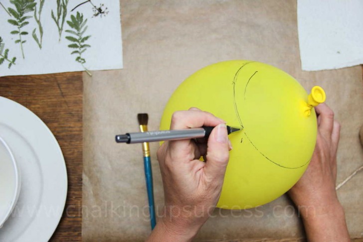 1. Gonfiate il palloncino fino ad ottenere le dimensioni desiderate per la lanterna, poi con un pennarello indicate la zona che coprirete di cartapesta