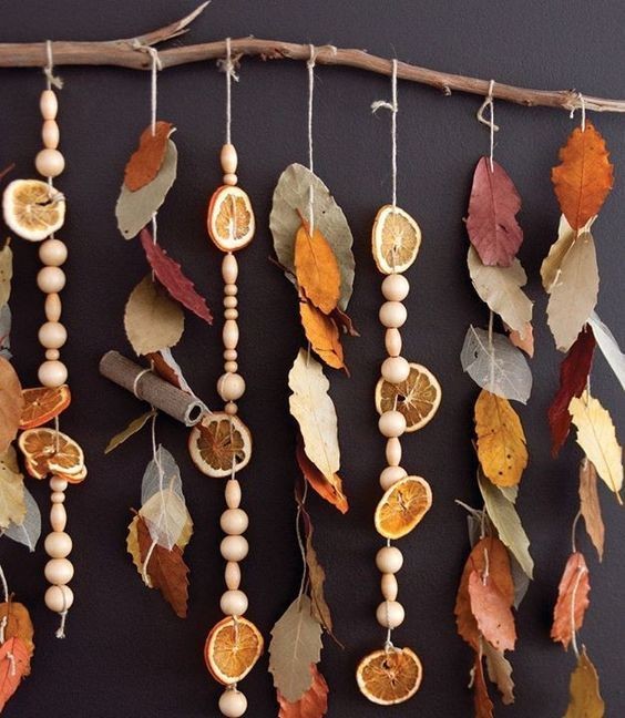 1. Una decorazione da parete con foglie, perle di legno e fette di arancia essiccate