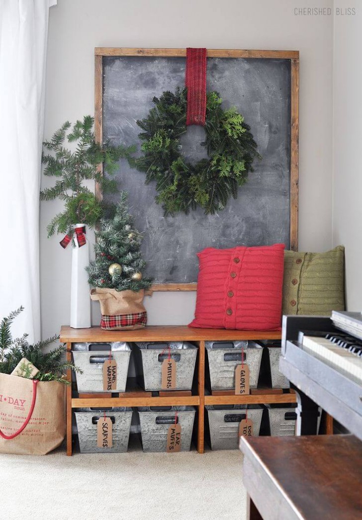 7. Een omvangrijke groene krans die opvalt op een groot schoolbord en kussens en naaldboomtakken om het kerstplaatje compleet te maken
