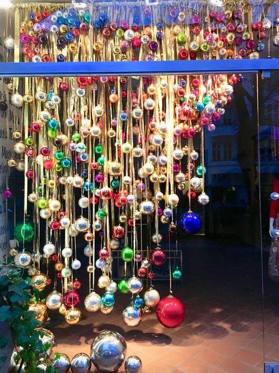 12.Een regen van gekleurde ballen met gouden linten van verschillende afmetingen: deze decoratie is in een winkel gebruikt , maar kan ook worden verkleind en aangepast worden aan ramen van het huis!