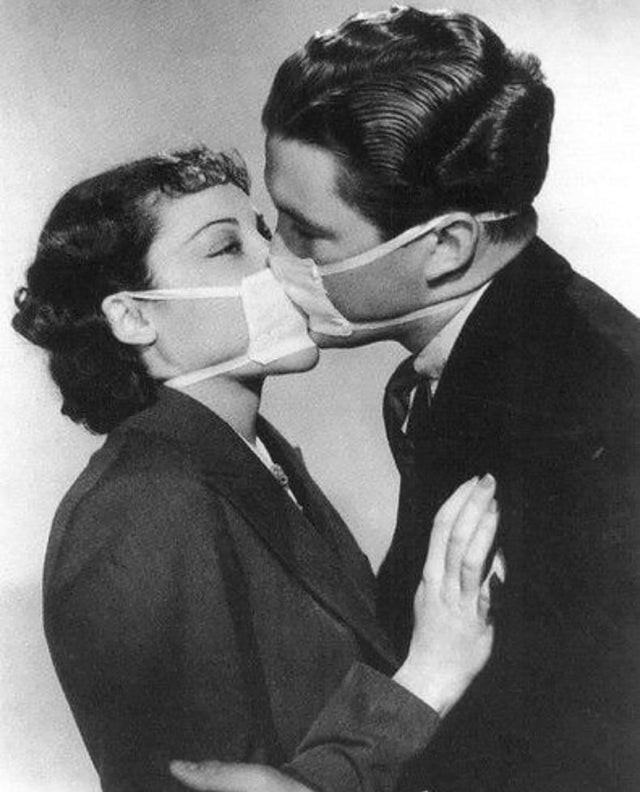 7. Una coppia di giovani innamorati resiste all'epidemia influenzale nel 1937, baciandosi con le mascherine chirurgiche...