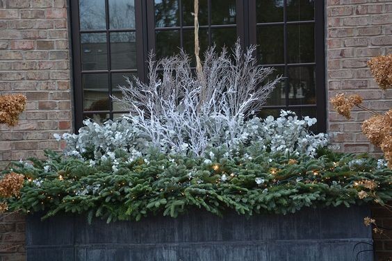 3. Vous aimez les couleurs froides ? Des branches de sapin blanc qui entourent ceux de plantes aux couleurs argentées sont une combinaison parfaite