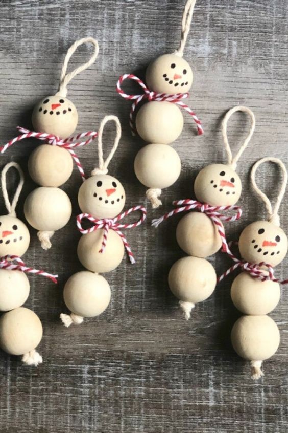 11. Met houten kralen maak je in een handomdraai mooie ornamenten in de vorm van sneeuwpoppen om op te hangen