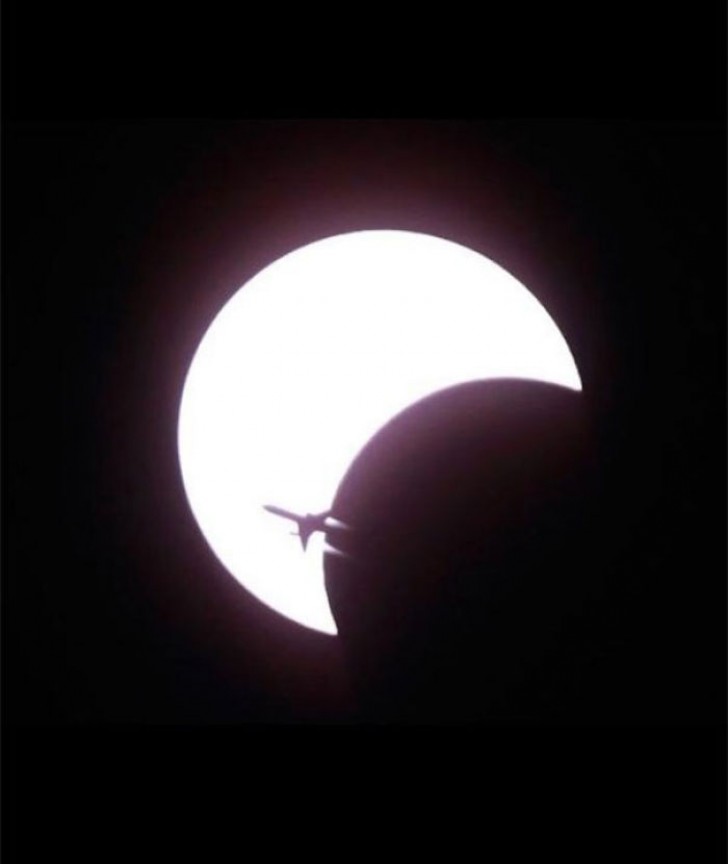 11. Ein Flugzeug, wie es in der Silhouette während der ersten Sonnenfinsternis des Jahrzehnts erscheint.