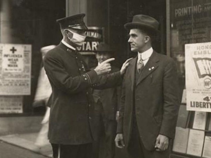 1. Een politieagent in San Francisco berispt een man op straat die ondanks de grieppandemie van 1918 geen beschermend masker draagt