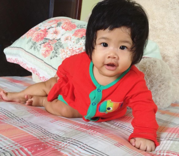 3. This little girl poses for a photo, and the first thing you notice is her helmet of very black hair.