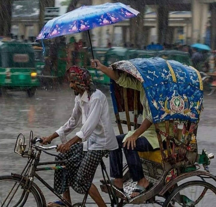 6. La persona detrás está cubierta, pero la persona que guía la bicicleta no: a veces basta solo ofrecer el paraguas.