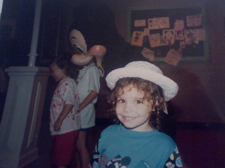13. La petite fille pose joyeusement avec son chapeau, mais derrière la souris semble avoir d'étranges intentions.
