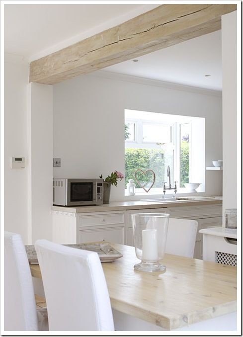 9. Met slechts één lichte, onafgewerkte houten balk wordt een moderne keuken verrijkt met een subtiel rustiek element