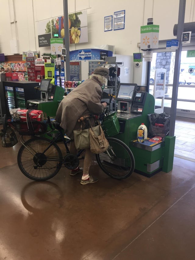 This elderly customer refuses to get off her bicycle, even in the supermarket!