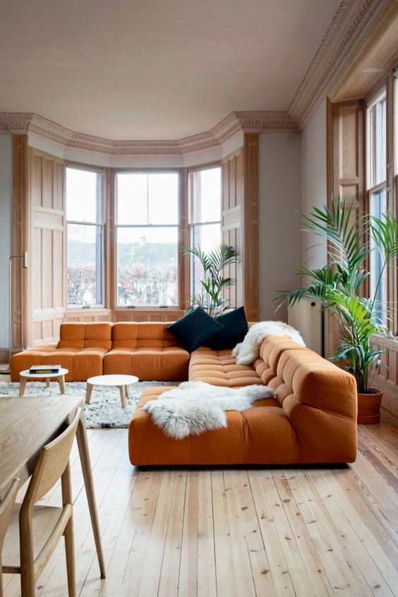 6. Guardate come si inserisce bene questo ampio divano colo zucca in una stanza dominata da tonalità di legno chiare e rilassanti