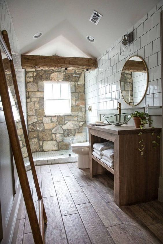 4. Een stenen muur, houten meubelen maar met een eenvoudiger en strakker design, en tegels: over het geheel genomen is de badkamer modern maar met een vleugje country