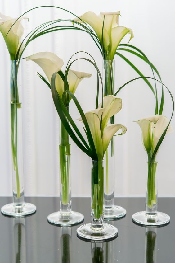 2. Plaats de stengels in smalle glazen of hoge, smalle kandelaars, één tot drie bloemen (en een paar draadvormige blaadjes) per houder