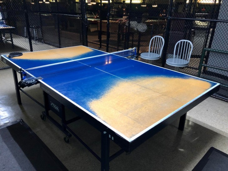A ping pong table which has lost it's color from so much use...