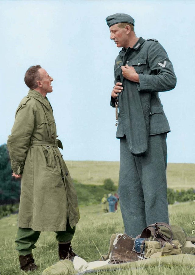 12. De Duitse soldaat Jakob Nacken (221 cm) praat met de Britse korporaal (160 cm) Bob Roberts nadat hij zich aan hem heeft overgegeven in de buurt van Calais, in Frankrijk (1944)