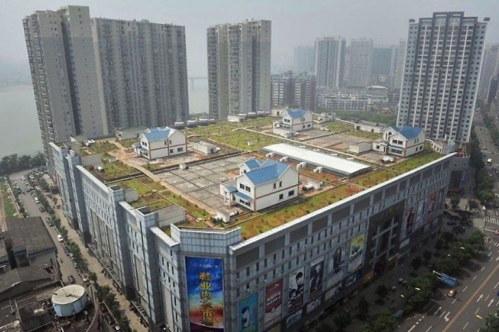 18. Private Villen auf dem Dach einer Shopping-Mall, umgeben von einer Betonlandschaft.