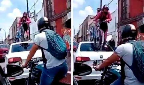 Ein Auto blockiert den Radweg: eine Radfahrerin klettert mit ihrem ganzen Fahrrad darauf, um durchzukommen - 1