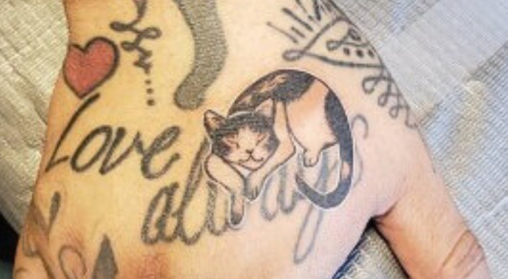 Tatuaggio stilizzato di un gatto che dorme su una mano