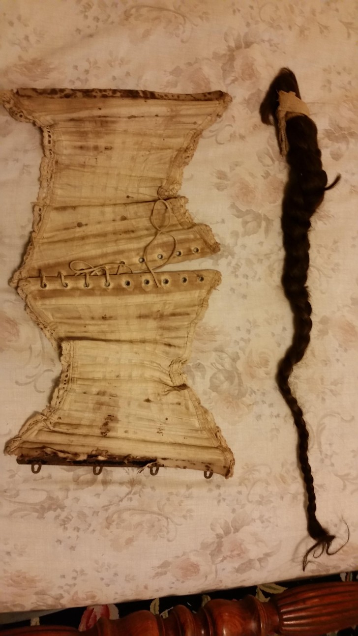 Un corsetto antico e una treccia di capelli scuri