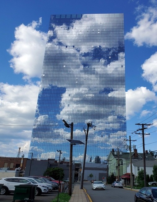 8. "De glazen ramen van een wolkenkrabber op een gedeeltelijk bewolkte dag"