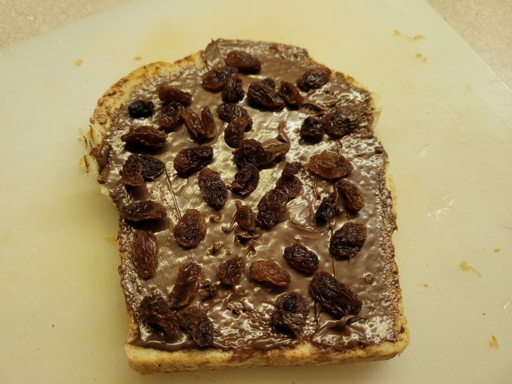15. Rozijnen op een sneetje brood smeren met nutella: het ziet er niet lekker uit.