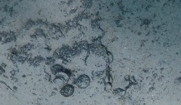 En dykare hittar gamla bronsmynt på Sardinien